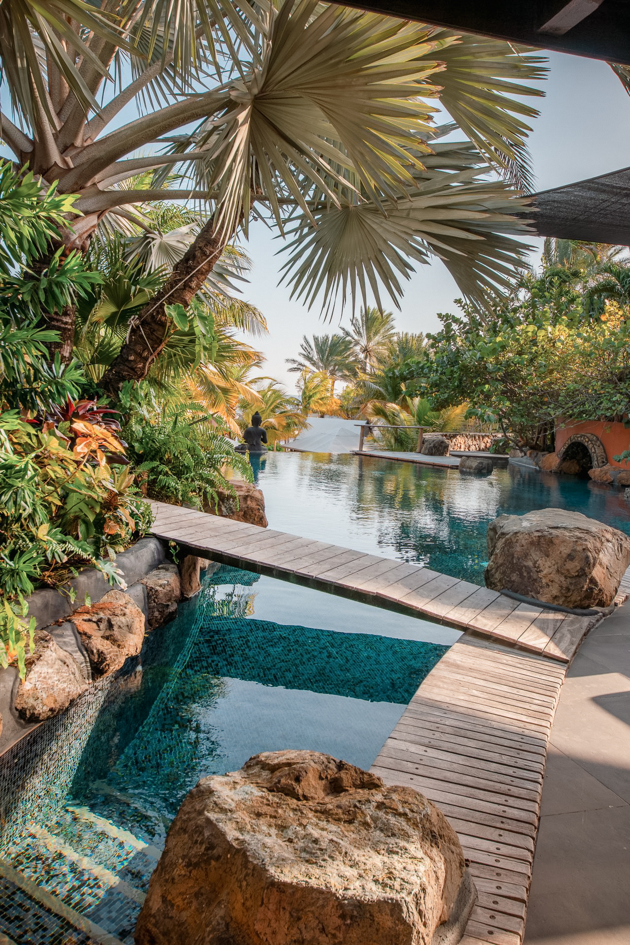 Sunlit private pool at the Baoase Master Villa with lush tropical greenery, inviting lounge spaces, and a tranquil, secluded atmosphere.