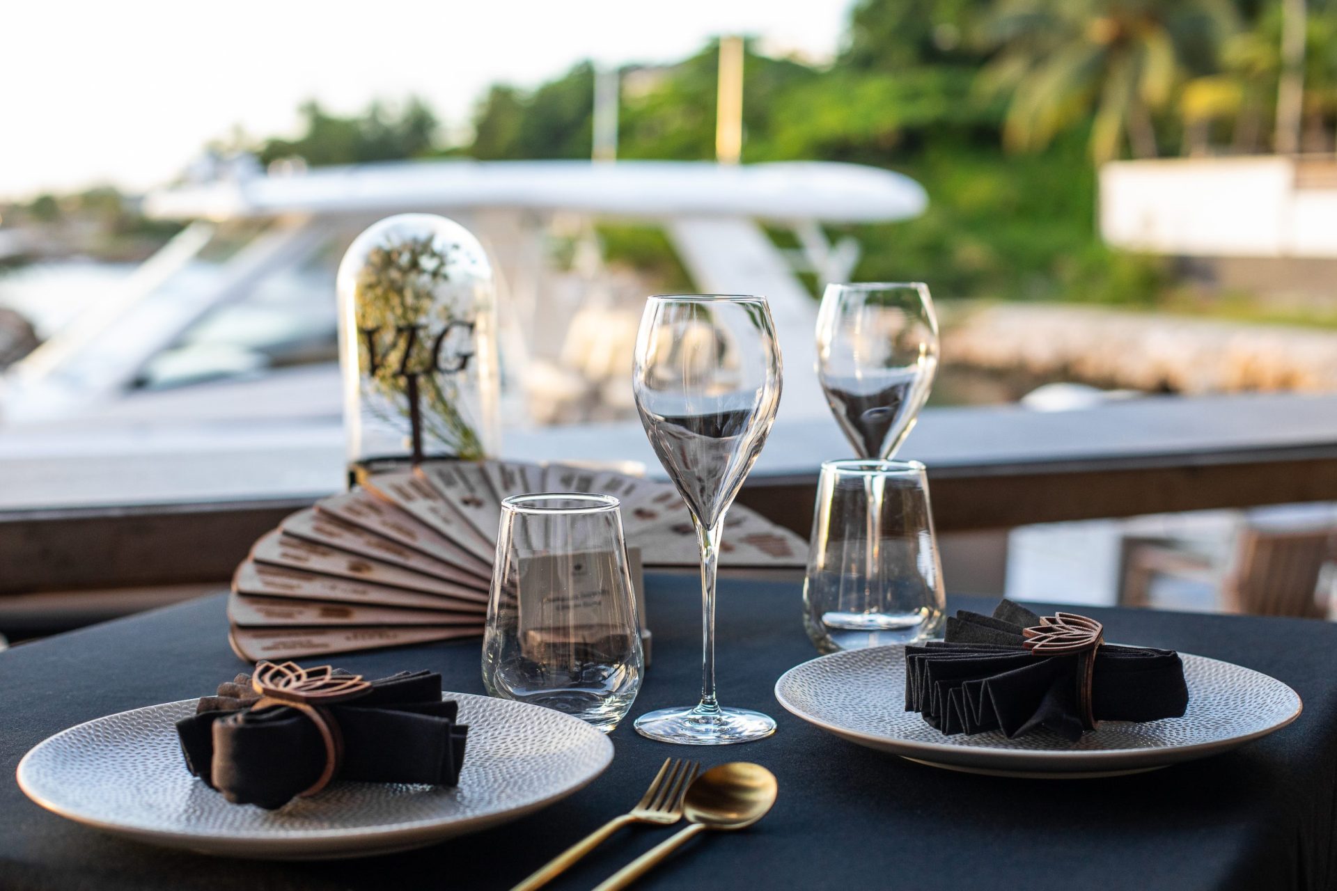 Close-up of a table set up for dining with a yacht in the background