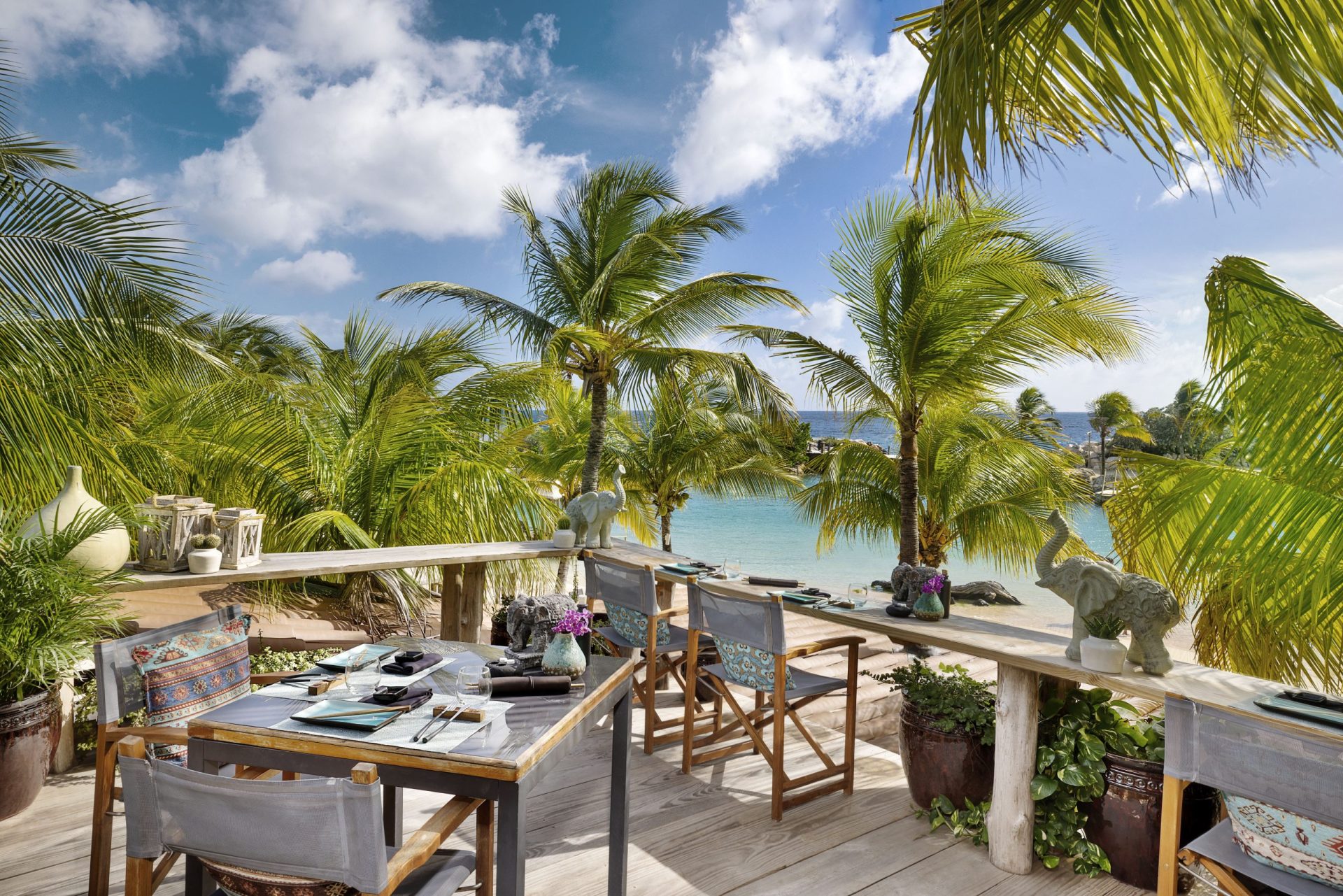 Terrace of the restaurant at Baoase with the beach, palm trees and sea in the background