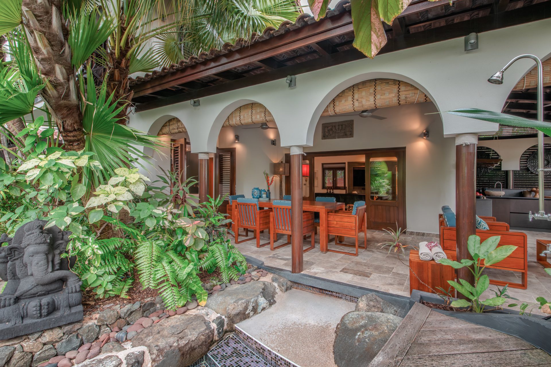 Exterior view of a Tropical Pool Villa surrounded by lush gardens with a private terrace and direct access to a serene infinity pool in Curaçao
