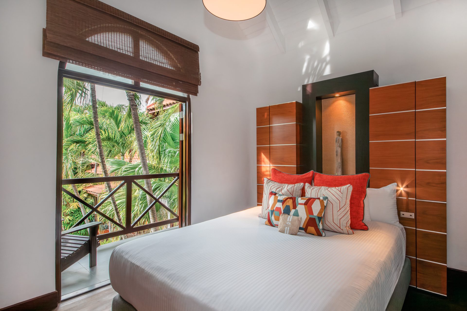 Elegant bedroom in a Tropical Pool Villa featuring soft natural tones, high ceilings, and a serene ambiance opening towards a private terrace in Curaçao