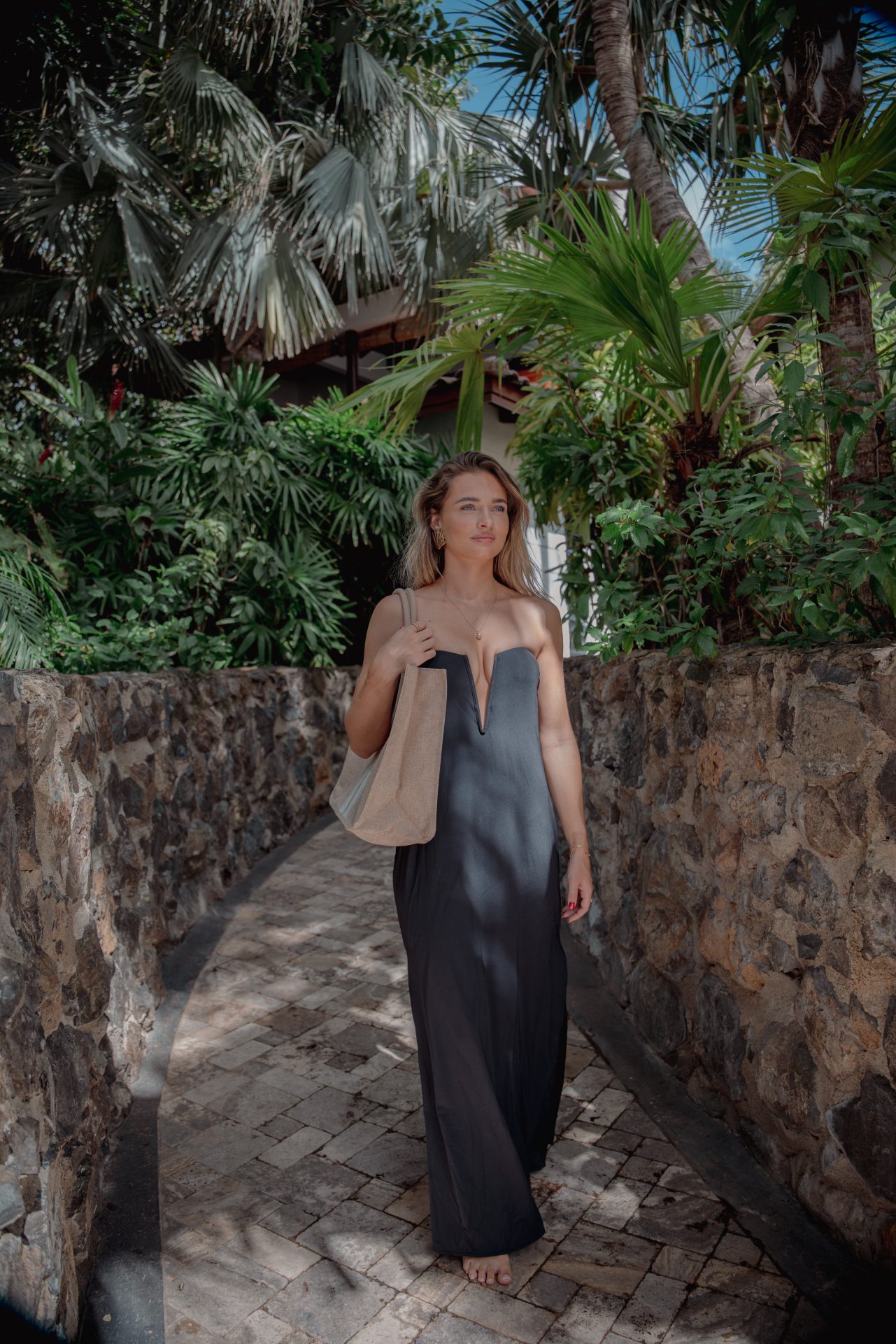 Woman wearing an elegant outfit from the Baoase Boutique and is surrounded by tropical greenery at Baoase Luxury Resort Curaçao.