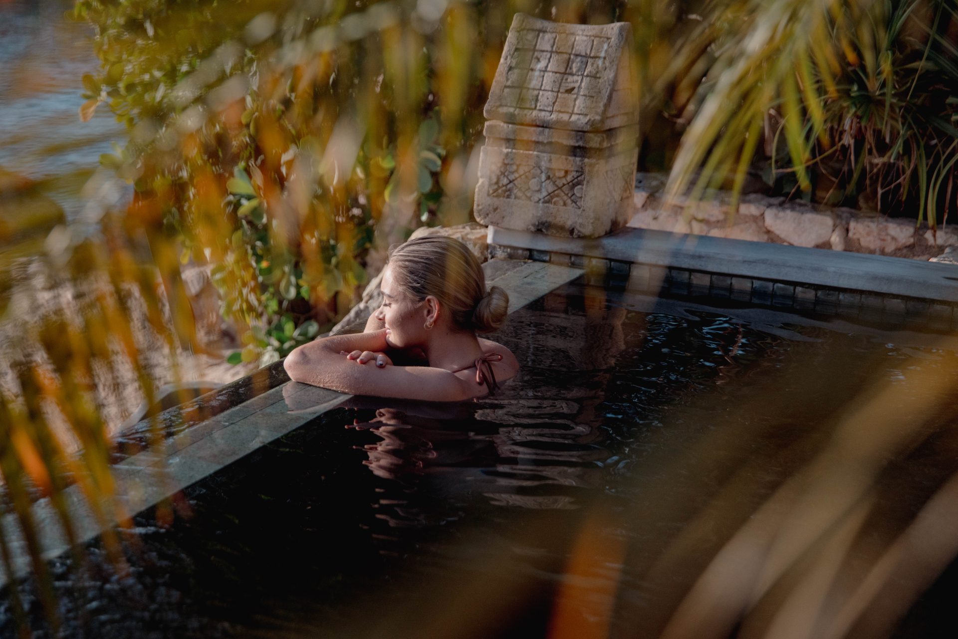 Guest relaxing in a private pool surrounded by tropical greenery at Baoase Curaçao.